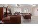 Wide shot of the living room, featuring tile floors, a ceiling fan, and large leather sofas at 11034 E Natal Ave, Mesa, AZ 85209