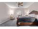 Spacious main bedroom with a ceiling fan, chair, and stylish sleigh bed at 11034 E Natal Ave, Mesa, AZ 85209