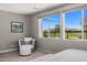 Bedroom sitting area with golf course views visible through large windows, and a sitting chair at 11172 N San Clemente St, Surprise, AZ 85388