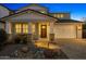 Charming two-story home featuring a well-manicured yard, stone accents, and a welcoming front porch in the evening light at 11172 N San Clemente St, Surprise, AZ 85388