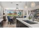 Bright, open-concept space featuring a kitchen island, dining area, and living area with a sliding glass door to the backyard at 11172 N San Clemente St, Surprise, AZ 85388