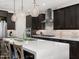Stylish kitchen featuring a large island with seating, modern appliances, and dark wood cabinets at 11172 N San Clemente St, Surprise, AZ 85388