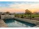 Backyard pool with rock waterfall feature offering golf course and mountain views in the distance at 11172 N San Clemente St, Surprise, AZ 85388