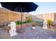 Inviting backyard with a paved patio, lush greenery, and elegant lion statues, perfect for relaxation at 11182 S Hopi Dr, Goodyear, AZ 85338