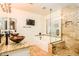 Luxurious bathroom featuring a double vanity, soaking tub, and a glass-enclosed shower at 11182 S Hopi Dr, Goodyear, AZ 85338