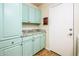 The laundry room features stylish blue cabinets, granite countertops, and a side entry door at 11182 S Hopi Dr, Goodyear, AZ 85338