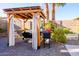 Charming patio features a grill, flower planter and wooden pergola, perfect for outdoor cooking and entertaining at 11182 S Hopi Dr, Goodyear, AZ 85338