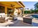 Inviting covered patio featuring comfortable seating, a ceiling fan, and a cozy fire pit, perfect for outdoor relaxation at 11182 S Hopi Dr, Goodyear, AZ 85338