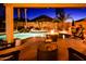 A beautiful backyard with a large swimming pool, a rock waterfall feature, and an outdoor fire pit at 11182 S Hopi Dr, Goodyear, AZ 85338