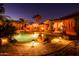 Serene backyard pool area with lush tropical landscaping and a cozy fire pit under the covered patio at 11182 S Hopi Dr, Goodyear, AZ 85338