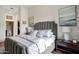 This bedroom features a beautiful bed with a padded headboard, two lamps, and an entrance to the bathroom at 11640 N Tatum Blvd # 3069, Phoenix, AZ 85028