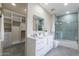 Bathroom featuring a double vanity, a tiled shower/bath, and a spacious walk-in closet, designed for comfort and convenience at 12201 N 65Th St, Scottsdale, AZ 85254