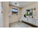 Well-lit bathroom with a modern vanity, sleek fixtures, and a large window offering plenty of natural light at 12201 N 65Th St, Scottsdale, AZ 85254