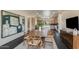 Open dining room with a large wood table, modern chandelier, and views into the kitchen and living areas at 12201 N 65Th St, Scottsdale, AZ 85254
