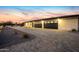 Modern home featuring a spacious three-car garage and extended driveway at sunset at 12201 N 65Th St, Scottsdale, AZ 85254