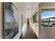 Elegant hallway featuring contemporary artwork and a bright view to the backyard entertainment area at 12201 N 65Th St, Scottsdale, AZ 85254