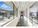 Hallway with large windows offering natural light, modern artwork, and access to outdoor living space at 12201 N 65Th St, Scottsdale, AZ 85254