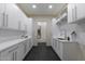 Well-lit laundry room with modern white cabinetry, subway tile backsplash, sink, and black tile floors at 12201 N 65Th St, Scottsdale, AZ 85254