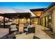 Spacious patio with multiple seating areas under a pergola, offering a serene outdoor living experience at 12201 N 65Th St, Scottsdale, AZ 85254