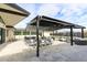 Outdoor patio area featuring a sleek pergola, comfortable seating, and travertine tile at 12201 N 65Th St, Scottsdale, AZ 85254