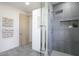 Modern shower with gray tile, a rainfall showerhead, and a frameless glass enclosure for a luxurious experience at 12201 N 65Th St, Scottsdale, AZ 85254