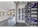 Contemporary glass-enclosed wine cellar featuring sleek, modern racking and ambient lighting at 12201 N 65Th St, Scottsdale, AZ 85254