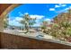 Balcony view featuring a colorful tree and a parking area under a sunny, partly cloudy sky at 12221 W Bell Rd # 249, Surprise, AZ 85378