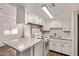 Bright kitchen with white cabinetry, appliances, and a breakfast bar area at 12221 W Bell Rd # 249, Surprise, AZ 85378