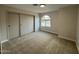 Neutral bedroom with carpet flooring, sliding closet doors, and a window at 1237 N Kenneth Pl, Chandler, AZ 85226