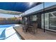 A backyard area with an in-ground pool, seating area, and shade sails over a grey painted patio at 13201 N 24Th Ave, Phoenix, AZ 85029