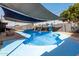 A backyard featuring a bright blue in-ground pool with slide, shaded by sails, perfect for summer days at 13201 N 24Th Ave, Phoenix, AZ 85029