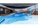 Large in-ground pool with slide and patio shaded by sails, perfect for summer fun in this private yard at 13201 N 24Th Ave, Phoenix, AZ 85029