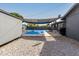 Backyard with covered in-ground pool, shed, seating area, and gravel, providing a versatile outdoor space at 13201 N 24Th Ave, Phoenix, AZ 85029