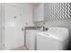 A laundry room with a washer, dryer, and cabinets overhead with grey and white chevron pattern at 13201 N 24Th Ave, Phoenix, AZ 85029