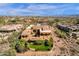 Aerial shot showcasing an expansive desert property with a lawn, covered patio, and lush landscaping at 14675 E Paradise Dr, Fountain Hills, AZ 85268