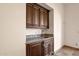 Dry bar area with dark wood cabinets and granite countertop offers space for entertaining at 14675 E Paradise Dr, Fountain Hills, AZ 85268
