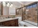 Elegant bathroom features a walk-in shower, soaking tub, a decorative light fixture, and stone countertops at 14675 E Paradise Dr, Fountain Hills, AZ 85268