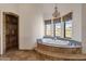 A bathroom featuring a luxurious bathtub, chandelier lighting, and scenic views from multiple windows at 14675 E Paradise Dr, Fountain Hills, AZ 85268