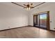 Bright bedroom with wood flooring, ceiling fan, base molding, and sliding glass door at 14675 E Paradise Dr, Fountain Hills, AZ 85268