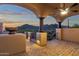 This covered patio features desert mountain views, brick flooring, and an outdoor ceiling fan at 14675 E Paradise Dr, Fountain Hills, AZ 85268