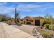 Stunning desert home with a circular brick driveway, desert landscaping, and a large cacti in the front yard at 14675 E Paradise Dr, Fountain Hills, AZ 85268