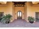 Inviting covered entrance with a wood beam, double doors, lush plants, and paver walkway at 14675 E Paradise Dr, Fountain Hills, AZ 85268