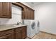 Well-equipped laundry room features modern appliances, a utility sink, granite countertops, and ample custom cabinetry at 14675 E Paradise Dr, Fountain Hills, AZ 85268