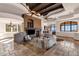 Spacious living room with a stone fireplace, beamed ceilings, and large windows at 14675 E Paradise Dr, Fountain Hills, AZ 85268