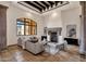 Living room featuring columns, travertine tile flooring, coffered ceilings, and a fireplace at 14675 E Paradise Dr, Fountain Hills, AZ 85268