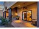 Covered patio featuring brick flooring, dark pillars, ceiling fan, and potted plants, with entry into the home at 14675 E Paradise Dr, Fountain Hills, AZ 85268