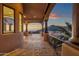 Expansive covered patio with brick flooring, stone columns, and stunning views of the surrounding mountain landscape at 14675 E Paradise Dr, Fountain Hills, AZ 85268
