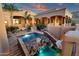 Outdoor oasis showcasing a multi-tiered pool, stone waterfall, and lush desert landscaping at 14675 E Paradise Dr, Fountain Hills, AZ 85268