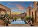 Scenic view of a backyard pool, surrounded by lush landscaping, and a bridge with desert sunset at 14675 E Paradise Dr, Fountain Hills, AZ 85268