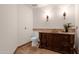 Stylish powder room is equipped with a custom wood vanity, stone countertops, and decorative sconce lighting at 14675 E Paradise Dr, Fountain Hills, AZ 85268